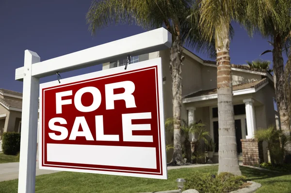 Красный для продажи недвижимости знак и дом — стоковое фото