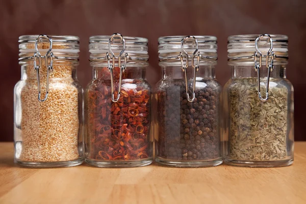 Glazen flessen van diverse koken specerijen — Stockfoto