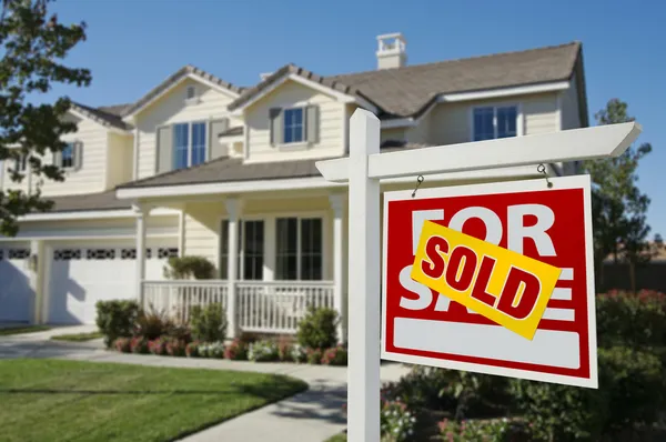 Sold Home For Sale Sign and New House Stockfoto