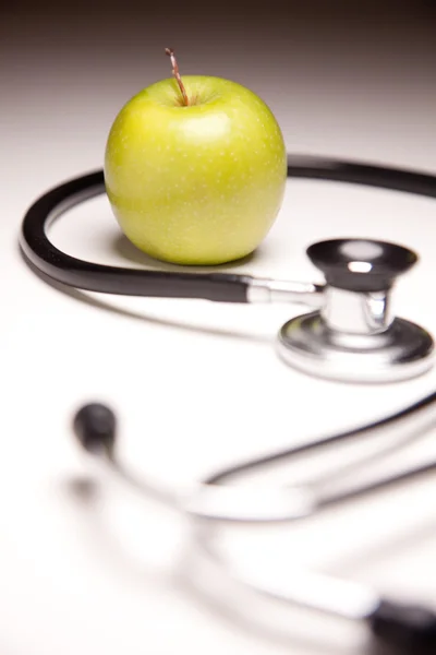 Стетоскоп і зелене яблуко — стокове фото