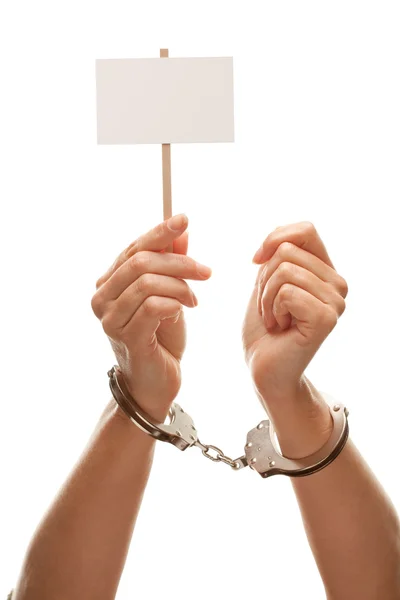 В наручниках женщина держит белый знак — стоковое фото