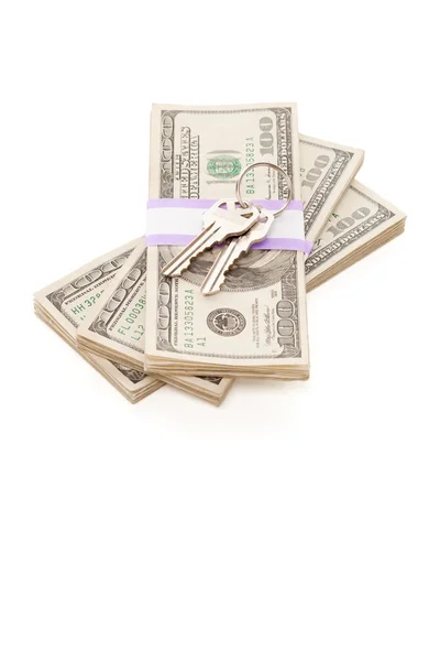 Chaves da casa na pilha de dinheiro isolado — Fotografia de Stock