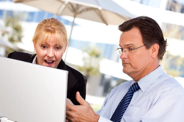 Empresário e mulher usando laptop — Fotografia de Stock