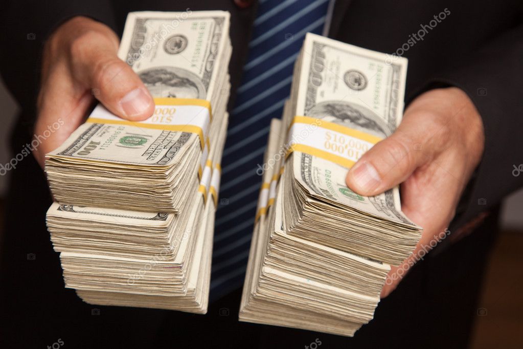 holding stack of 100 dollar bills