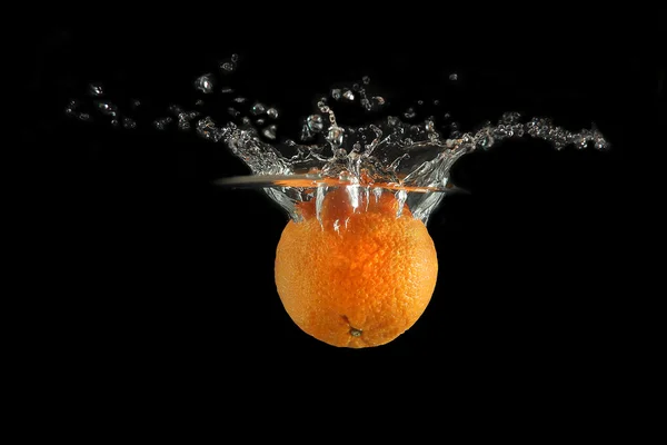 Tangerine falling into water Royalty Free Stock Photos