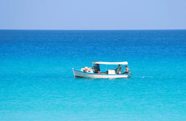 Маленькая рыбацкая лодка в спокойном синем море — стоковое фото