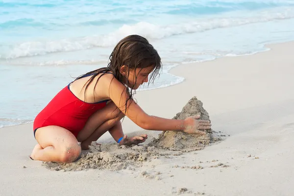 Beautiful latin building a sand castle in the bea — Stock Photo, Image
