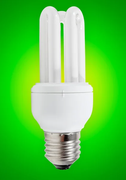 Енергозберігаюча лампа на зеленому тлі — стокове фото