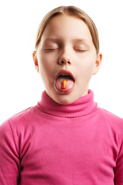 Little girl with orange pill isolated on — Stock Photo, Image