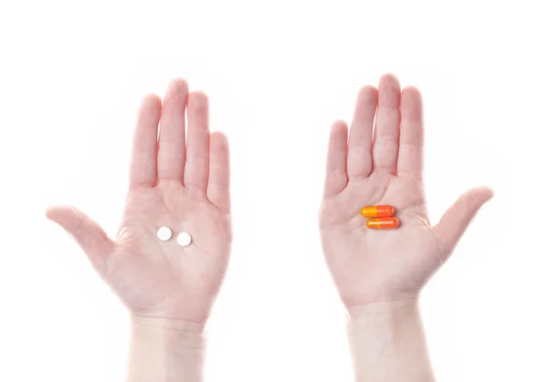 White pill in left hand and orange pills — Stock Photo, Image