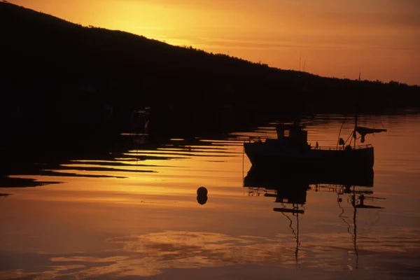 Barco de pesca ao pôr do sol / nascer do sol — Fotografia de Stock