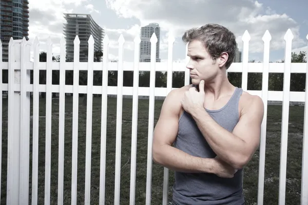 Man posing by a fence — Stock Photo, Image
