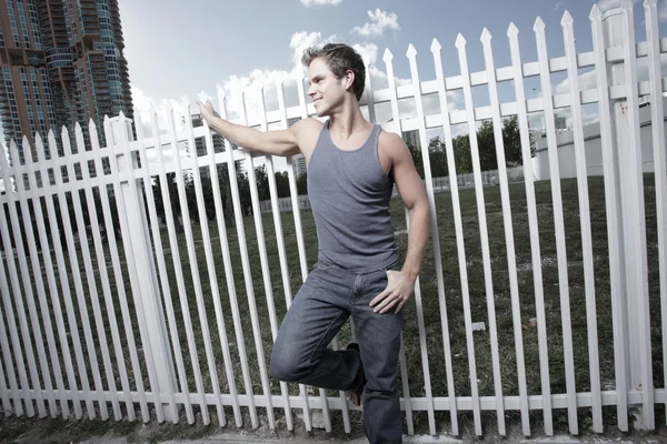 Man posing by a fence — Stock Photo, Image