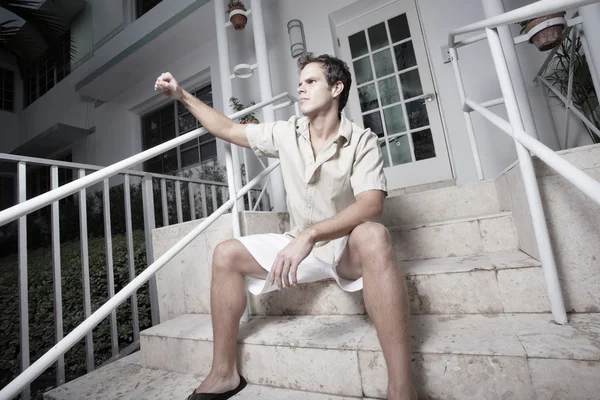 Чоловік сидить на сходах і показує кулак — стокове фото