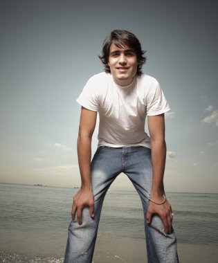 Young man on the beach clipart