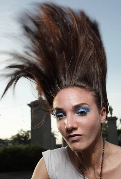 Vrouw wegknippen van haar haren in de lucht — Stockfoto