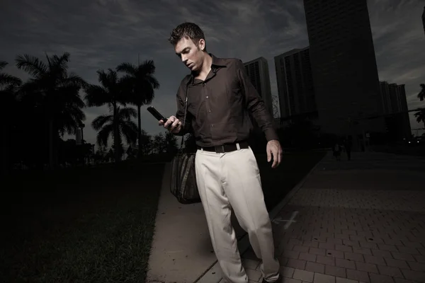 Homem andando à noite e discando seu telefone — Fotografia de Stock