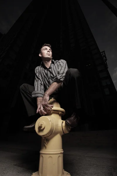 Homem posando em um hidrante — Fotografia de Stock