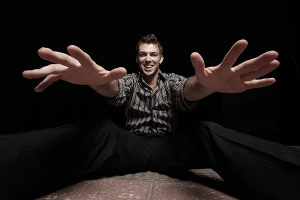 Homem sentado e estendendo as mãos — Fotografia de Stock