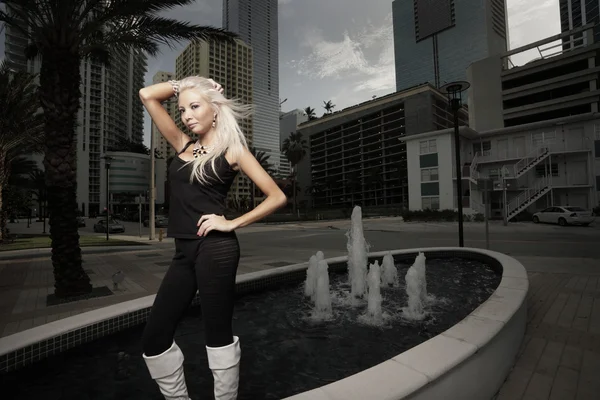 Attractive woman posing by a fountain — Stock Photo, Image