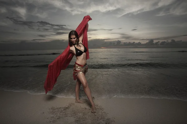 在海边与红色的面纱跳舞的女人 — 图库照片