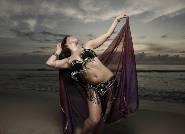 Frau tanzt am Strand mit lila Schleier — Stockfoto
