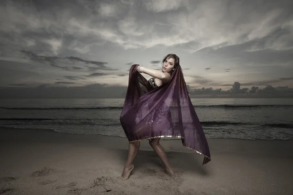 Γυναίκα, χορός στην παραλία με ένα μοβ πέπλο — Φωτογραφία Αρχείου