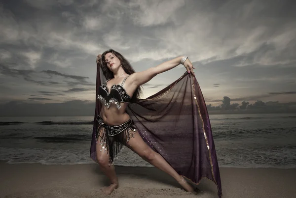stock image Woman dancing on the beach with a purple veil