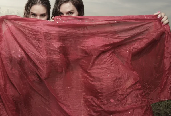 Frauen hinter rotem Schleier — Stockfoto