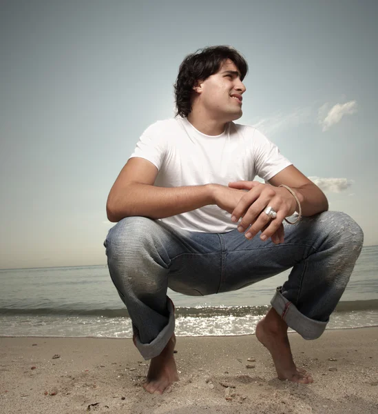 모래 위에 앉아 있는 사람 — 스톡 사진