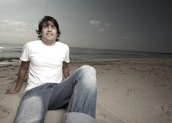 Muž sedící na písku — Stock fotografie