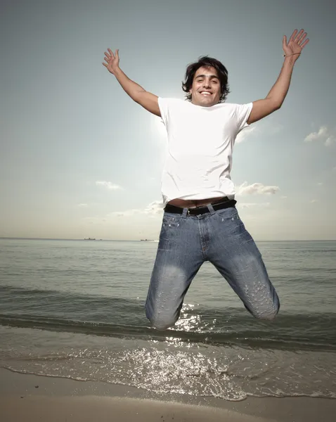 Adam sahilde sevinç için atlama — Stok fotoğraf