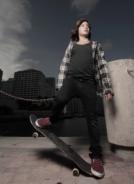 Giovane adolescente con uno skateboard — Foto Stock