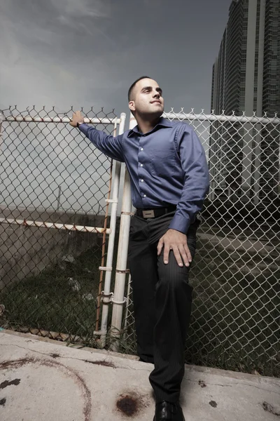 Imagen de un hombre de negocios joven y guapo posando junto a una cerca —  Fotos de Stock