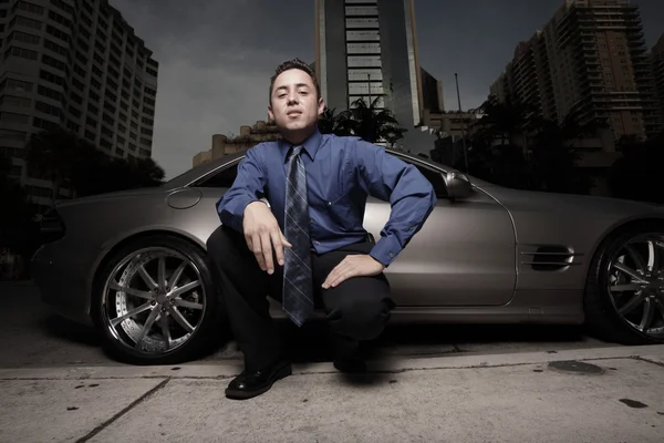 Geschäftsmann posiert mit einem Luxus-Sportwagen — Stockfoto