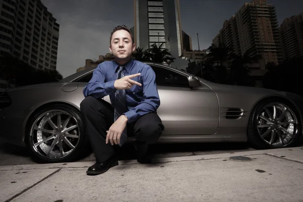 Geschäftsmann posiert mit Luxus-Sportwagen und gestikuliert — Stockfoto