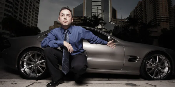 Geschäftsmann posiert mit Luxus-Sportwagen und gestikuliert — Stockfoto