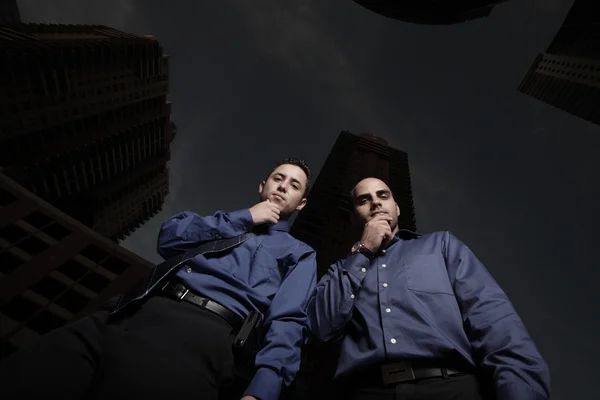 Dos hombres de negocios mirando hacia abajo con las manos en la barbilla — Foto de Stock