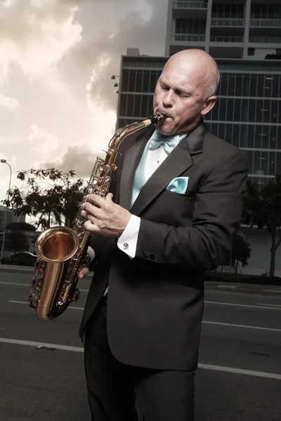 Handsome bald man playing a saxophone — Stock Photo, Image