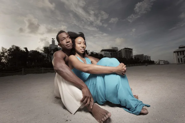 Mladý pár, seděl na písku — Stock fotografie
