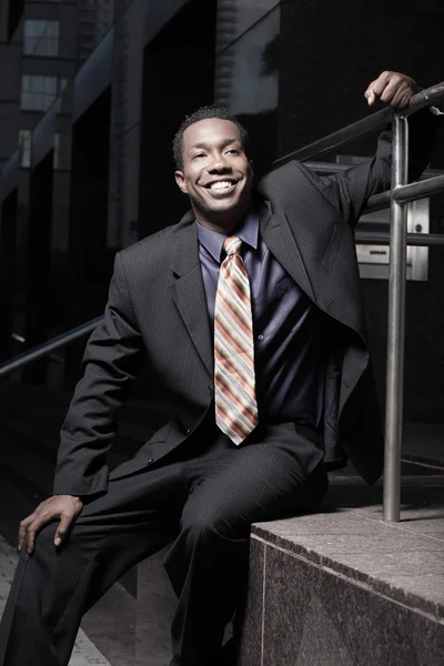 Joven hombre de negocios sonriendo y sentado — Foto de Stock