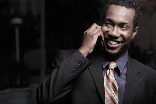 Boldog fiatal üzletember egy beszélő-ra egy mobiltelefon — Stock Fotó