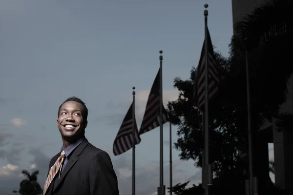 Podnikatel s americkou vlajkou v pozadí — Stock fotografie
