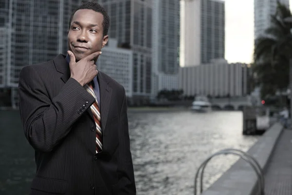Young African American businessman pondering in the city — Stock Photo, Image