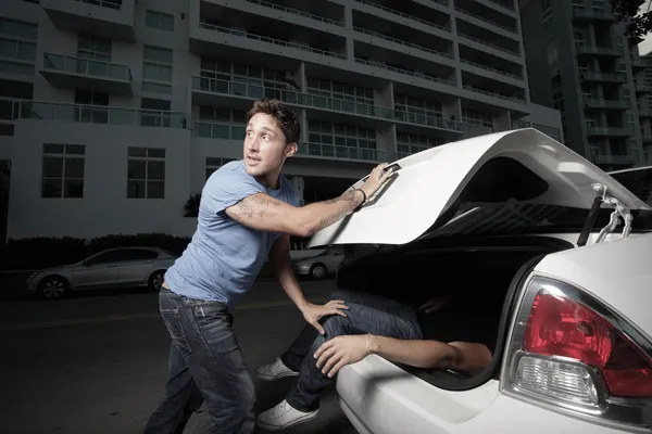 남자 트렁크에 그의 살인 피해자를 숨기기 — 스톡 사진