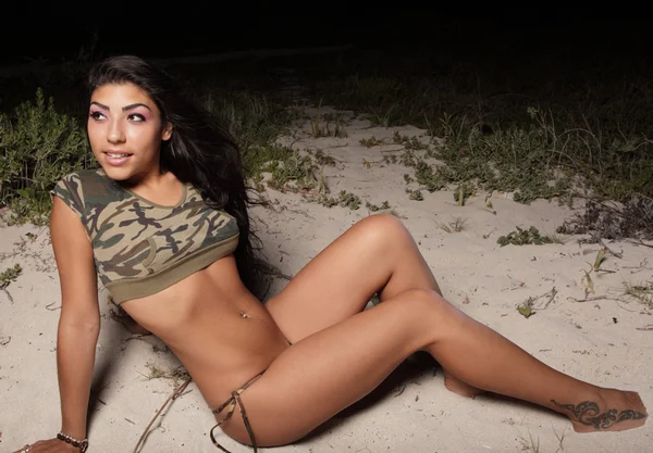 Сексуальная женщина позирует на песке — стоковое фото