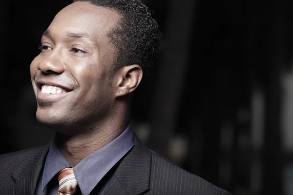 Kopfschuss eines jungen afrikanisch-amerikanischen Geschäftsmannes lächelnd Stockbild