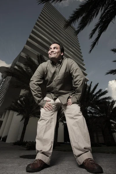 Un homme accroupi près d'un immeuble — Photo