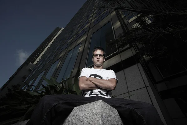 Homem sentado ao lado de uma borda do edifício — Fotografia de Stock