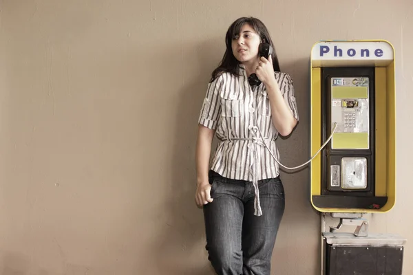 Woman talking on a payphone — Stock Photo, Image